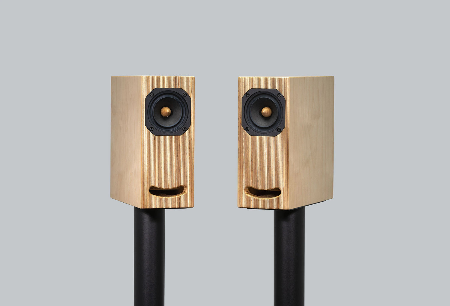 Closer Acoustics OGY bookshelf loudspeakers in natural plywood, placed on black stands for a contemporary and stylish sound solution