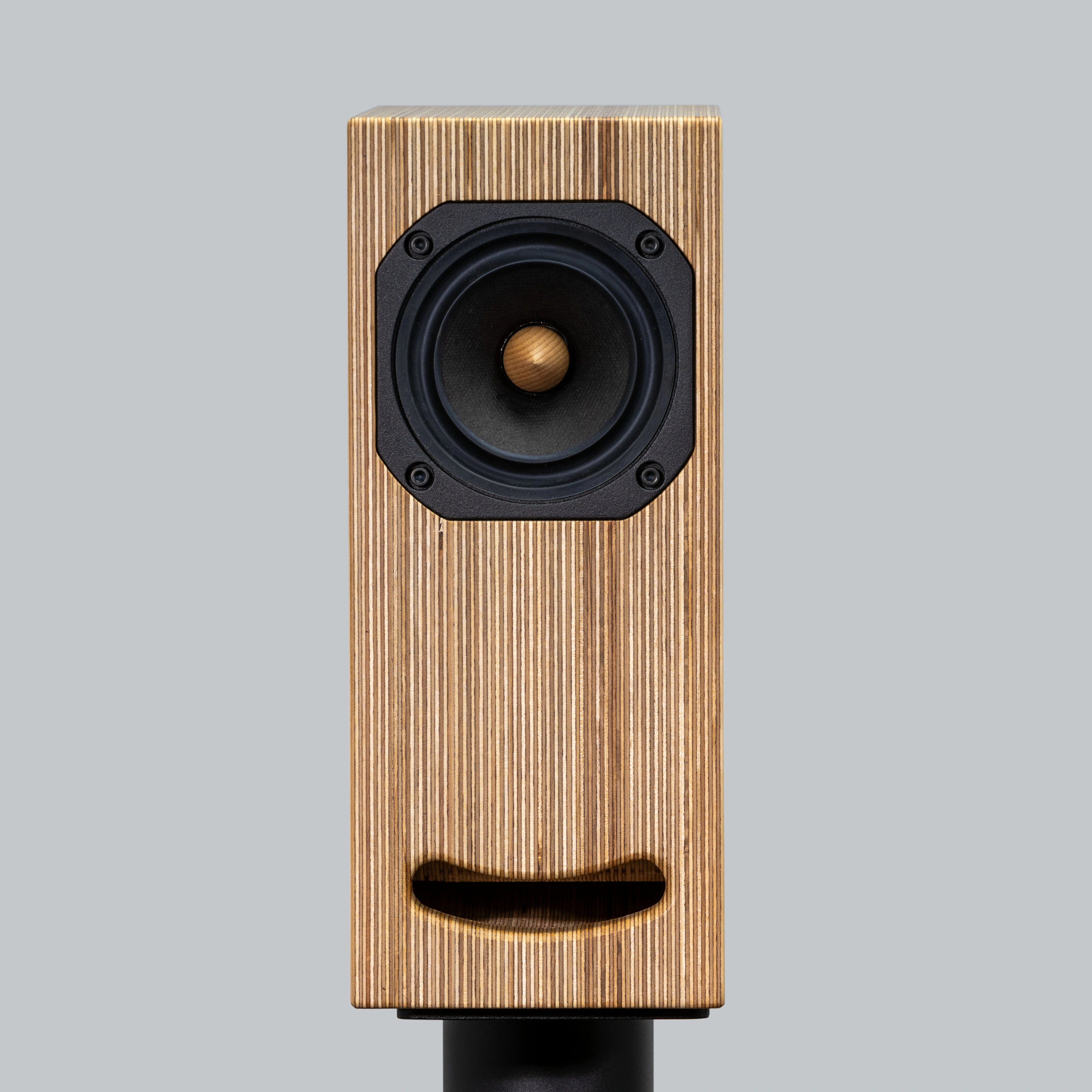 Closer Acoustics OGY Bookshelf Loudspeakers in plywood on black stand – full front view showcasing sleek design and superior audio performance