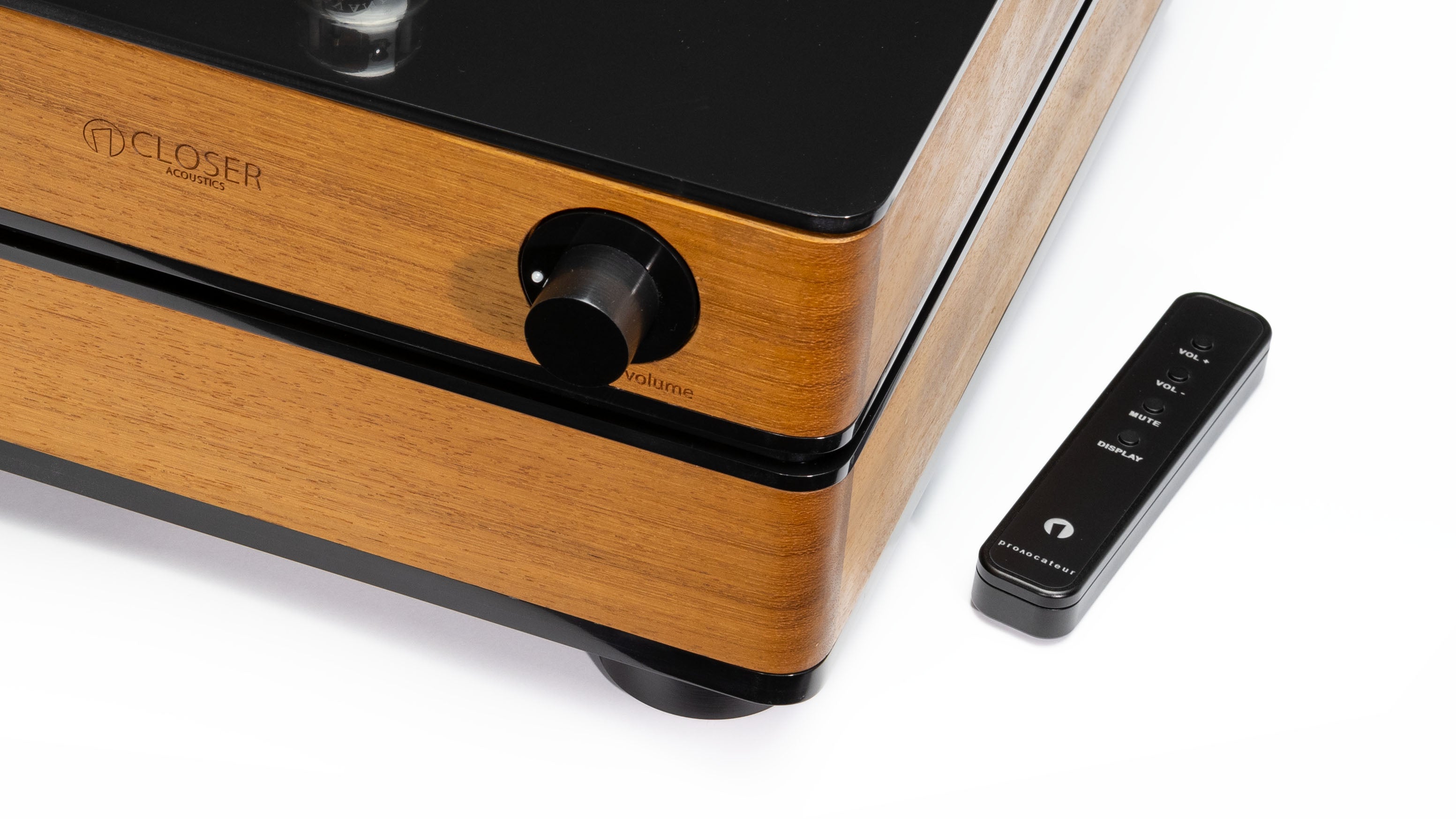 Corner view of the Closer Acoustics 300B Provocateur Signature integrated amplifier in Iroko finish, accompanied by the remote control, in a stylish setup.