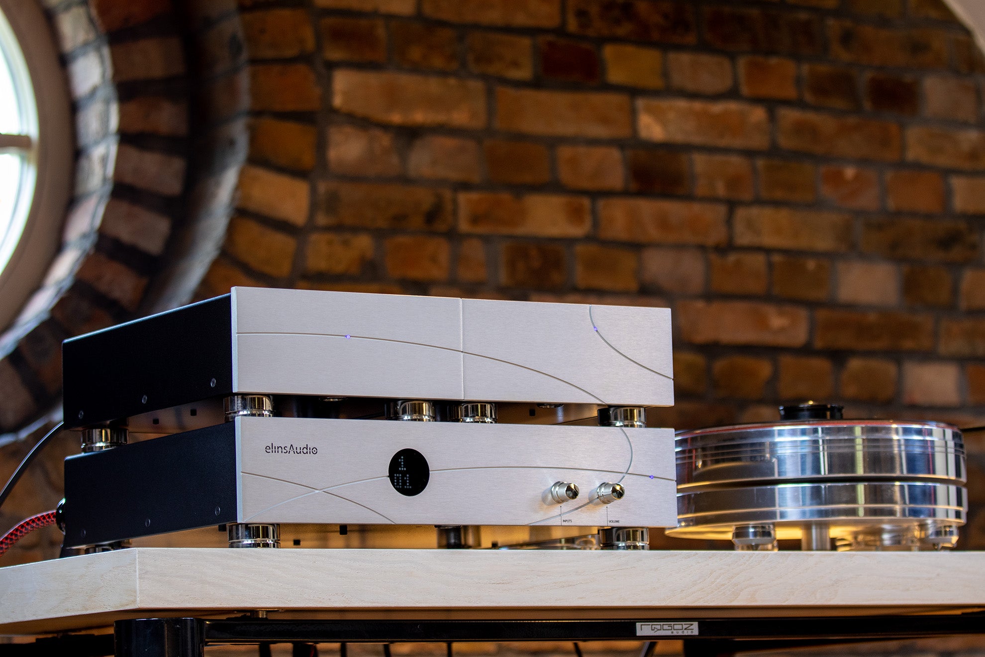 elinsAudio Mille Reference amplifier placed on a wooden table, showcasing its refined appearance and luxurious finish.
