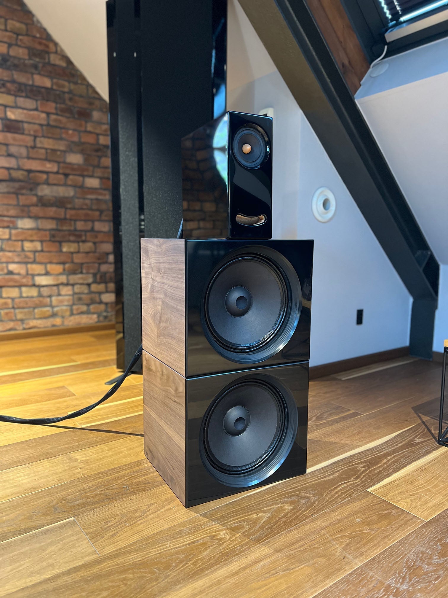 Closer Acoustics OGY Plus 2 x BOBs set in a listening room, featuring piano black fronts and walnut veneered sides, designed for superior audio performance and style