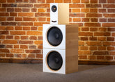 Closer Acoustics OGY plus 2 x BOBs set with white fronts and maple veneered sides, elegantly displayed against a textured brick wall for a sophisticated look