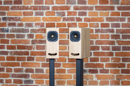 Closer Acoustics OGY Oak veneer bookshelf loudspeakers – wide angle shot displaying pair of speakers with refined oak veneer finish