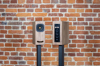 Closer Acoustics OGY bookshelf loudspeakers – one speaker front-facing and the other rear-facing, showcasing the detailed construction and sophisticated design